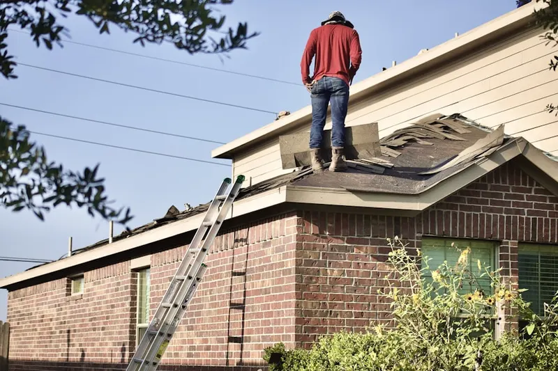Professional roofer working on a residential roof in Stiles